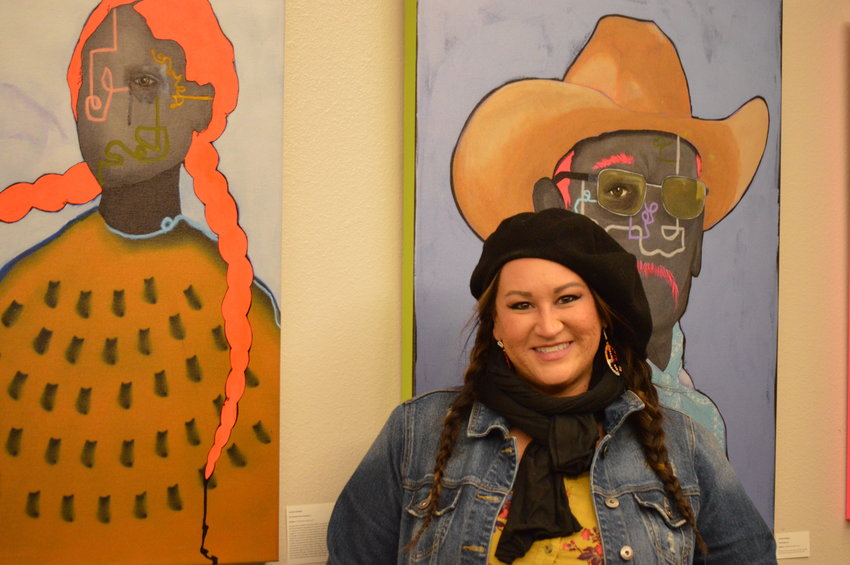 Danielle SeeWalker standing beside some of her artwork on display at Koelbel Library in Centennial on Nov. 10.